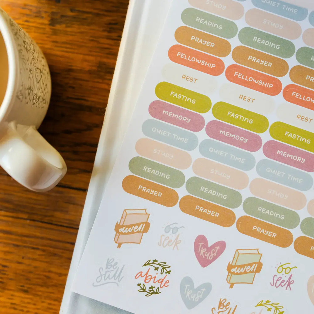 Colorful Bible study stickers featuring prayer, fellowship, and quiet time designs beside a coffee mug.