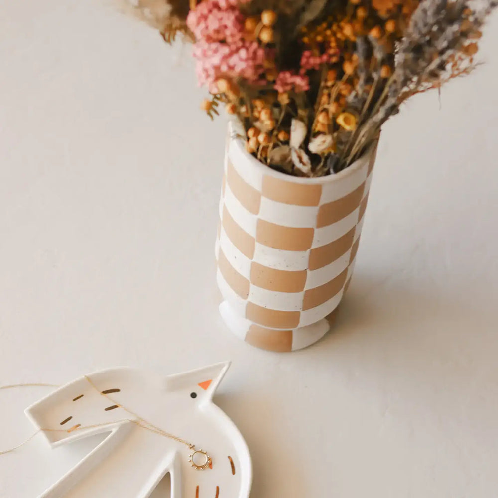 Holy Spirit trinket dish beside a striped vase with dried flowers, showcasing elegant decor and spiritual symbolism.