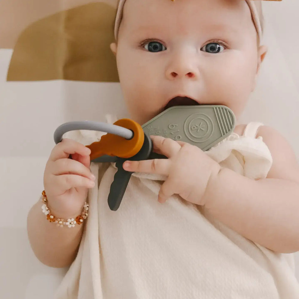 Baby enjoying the Keys to the Kingdom silicone teether, symbolizing faith and love, with colorful key designs.