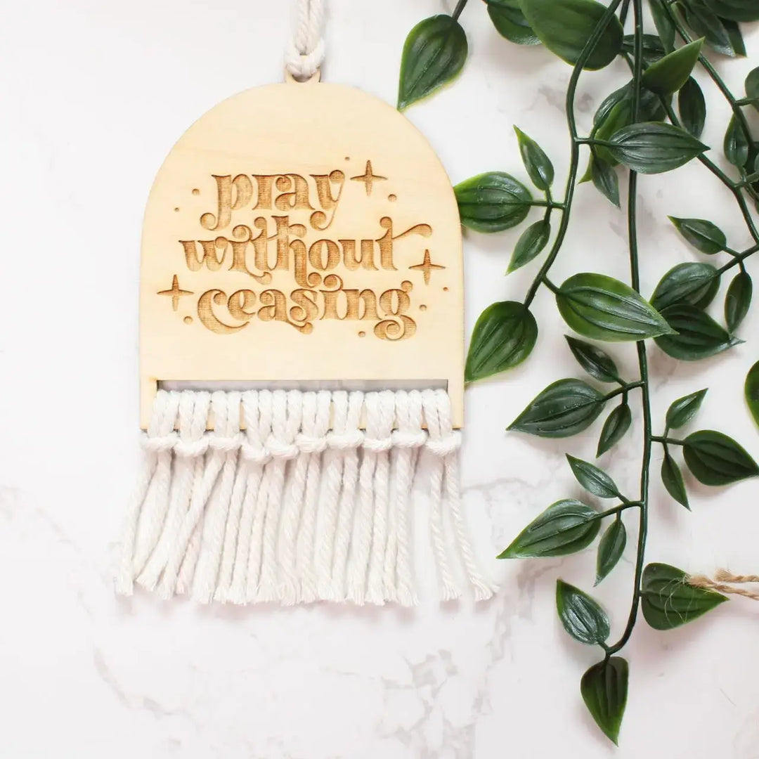 Handcrafted Pray Without Ceasing rearview mirror charm with macrame fringe and inspirational engraving.