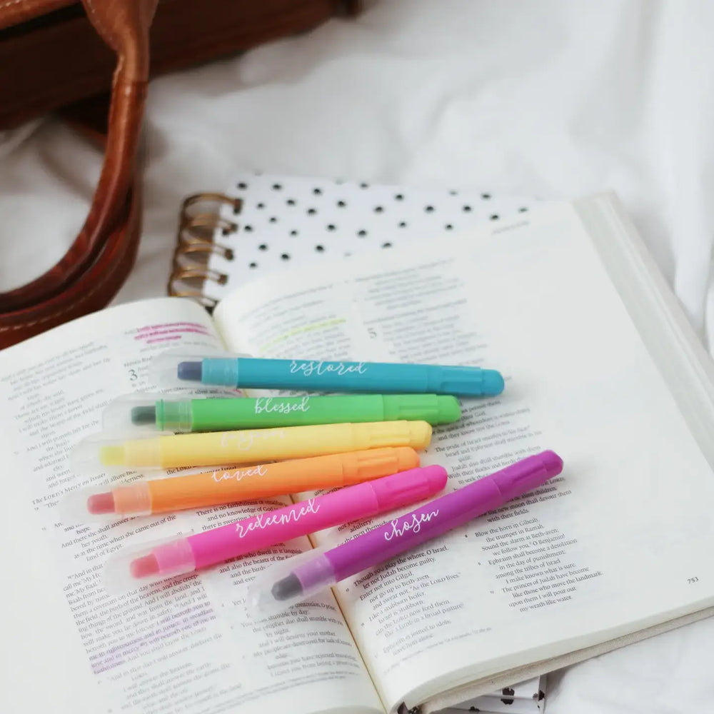 Colorful scented Bible highlighter set on an open page, showing six gel highlighters with inspirational words.