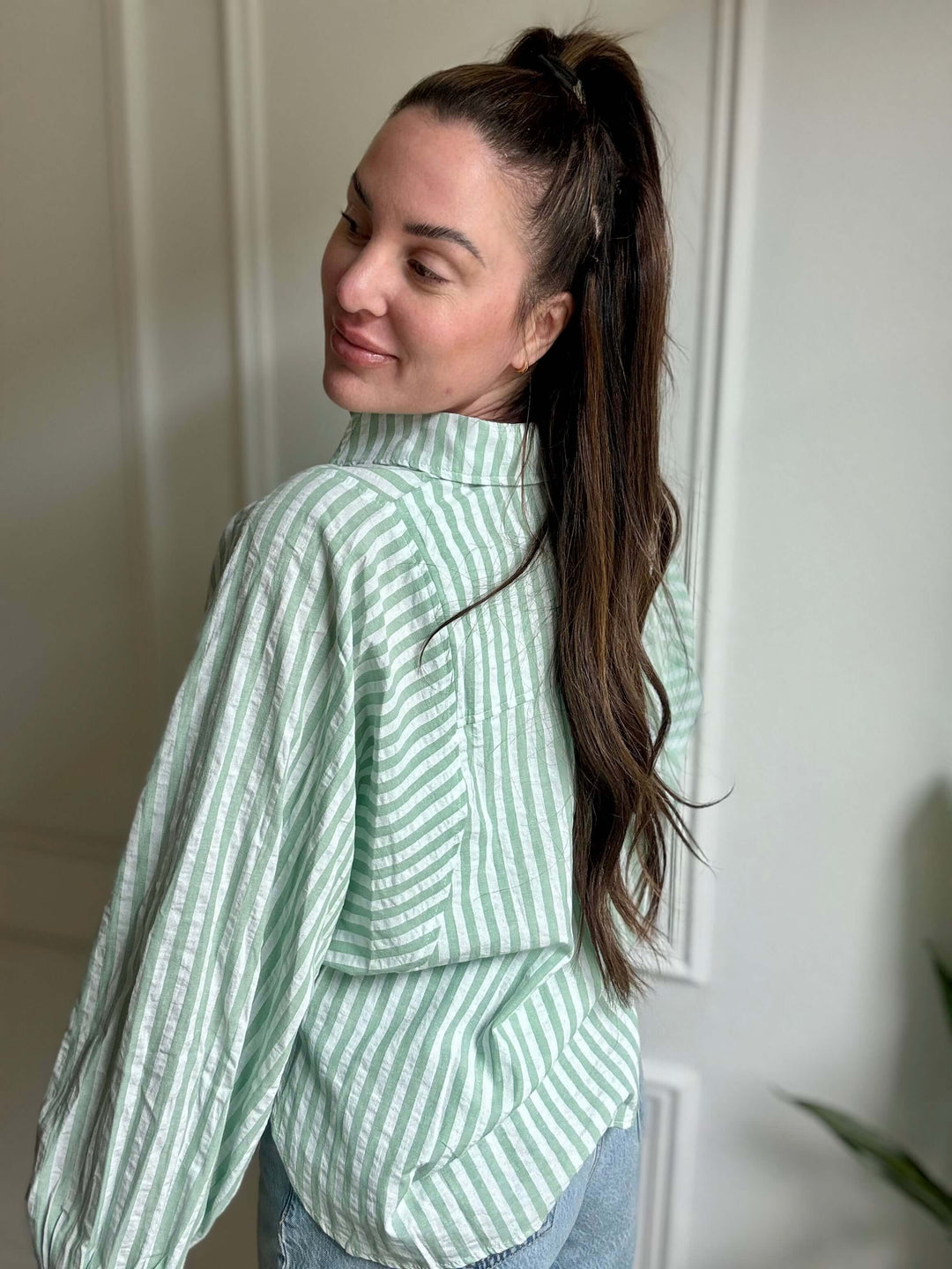 Christian women’s fashion featuring a woman in a green and white striped Flowy Stripes Button Down Shirt.