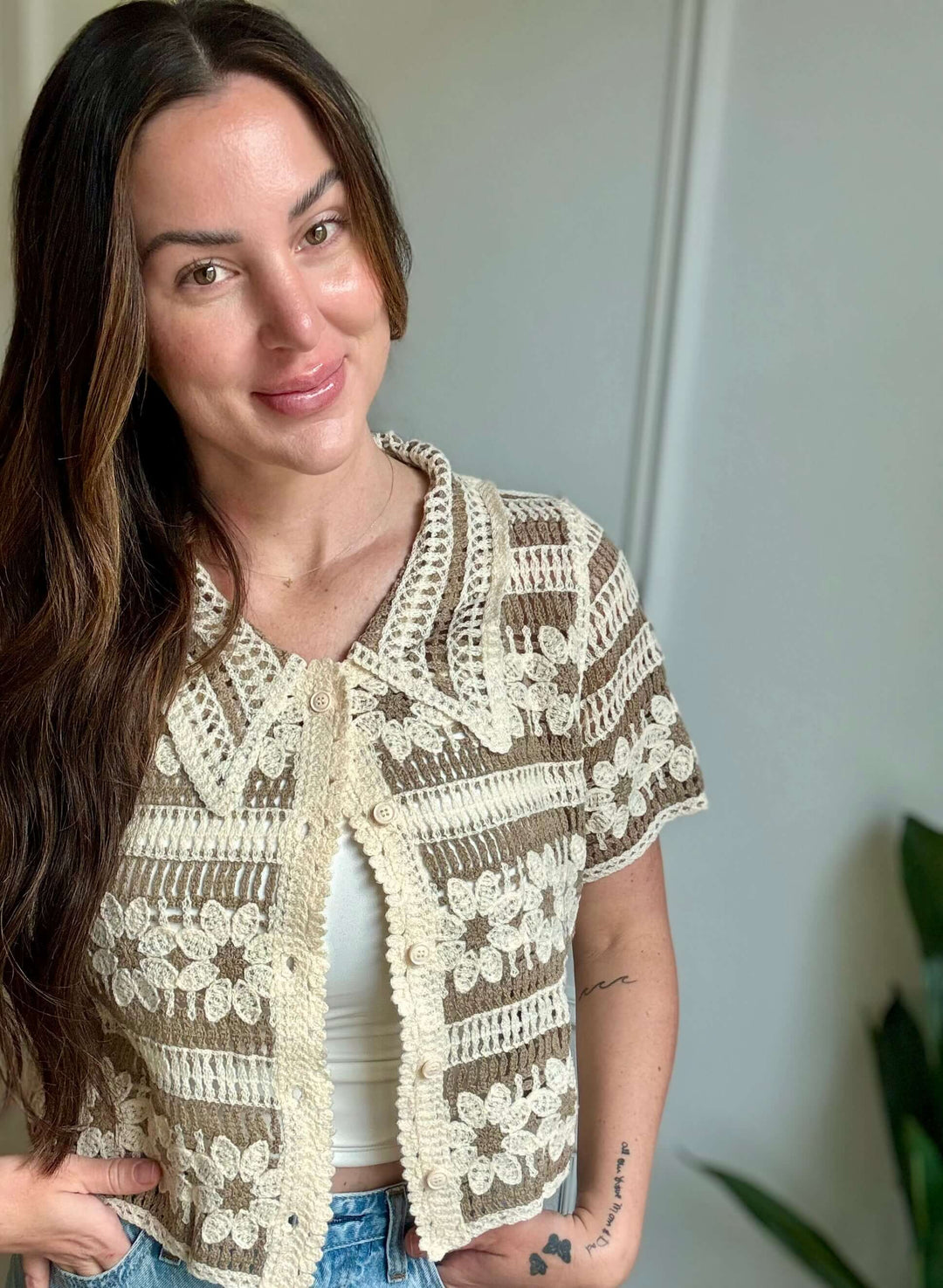 Charming woman modeling the Blossom Top, a floral crochet button-up in tan, perfect for Christian women's fashion.