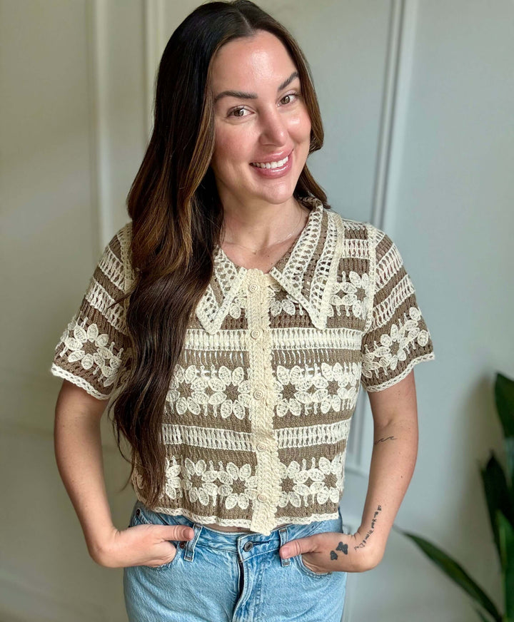 Woman smiling in a tan floral crochet button-up top, showcasing elegant Christian women's fashion.