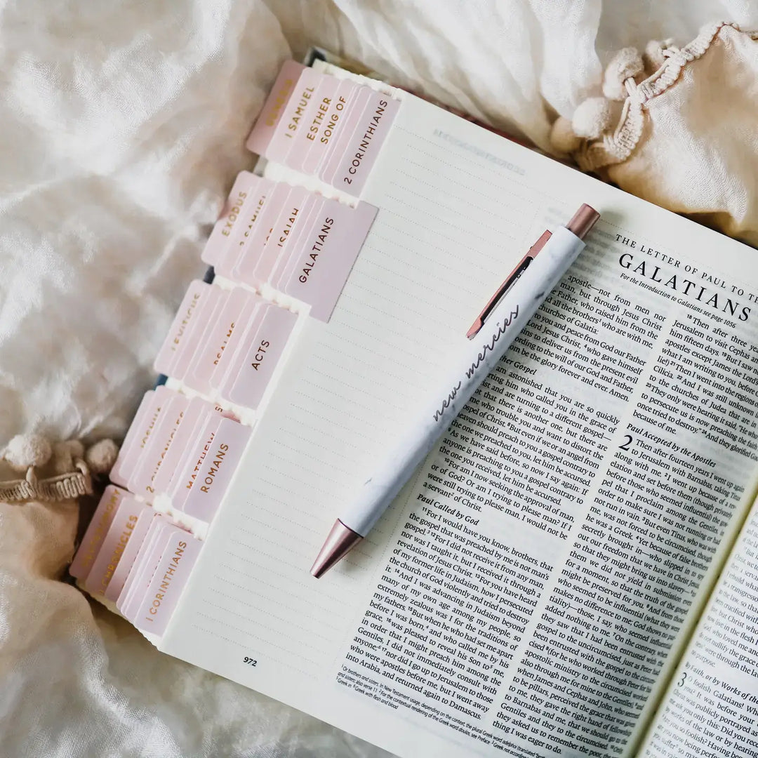 Blush Bible Tabs on an open Bible with a pen, showcasing organized Scripture books for easy navigation.