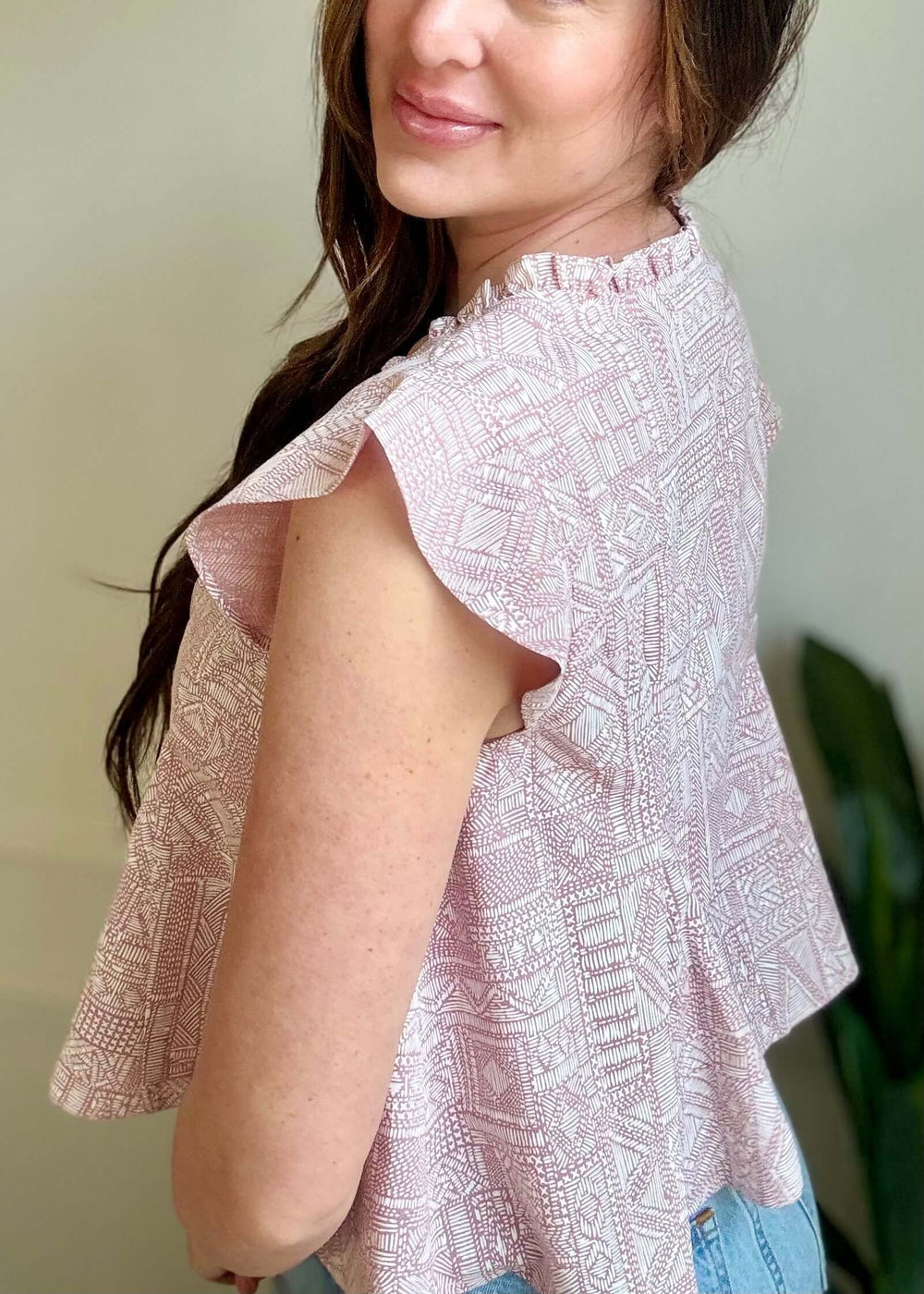 Model wearing Bohemian Grace Ruffle Tie-Front Blouse in mauve with ruffled shoulders and geometric print.