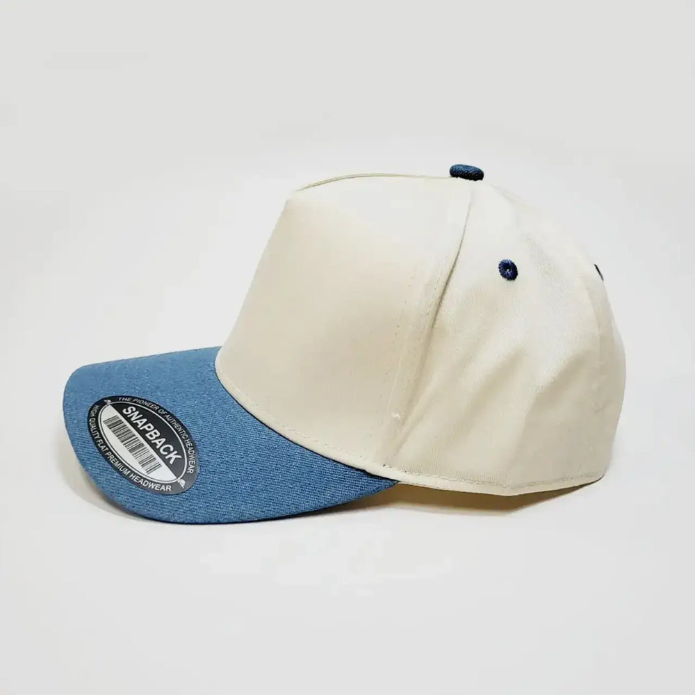 Stylish denim and cream snapback hat, featuring a structured design and adjustable closure for a perfect fit.