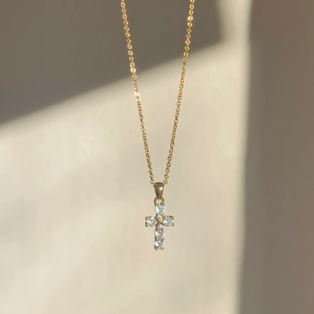 Elegant cubic zirconia cross pendant necklace on a gold chain, ideal for sensitive skin and adding a touch of grace.