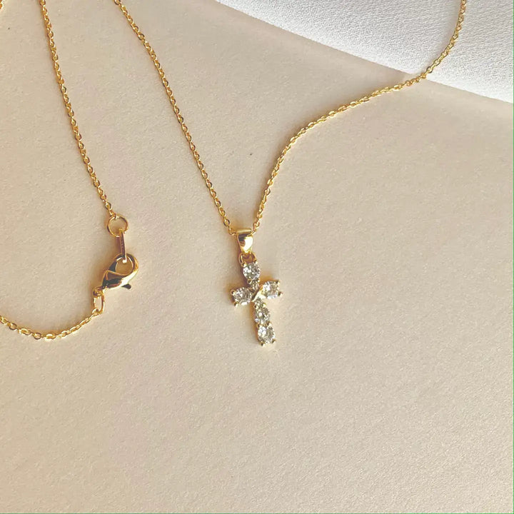 Elegant cubic zirconia cross pendant necklace on a delicate gold chain, perfect for sensitive skin.