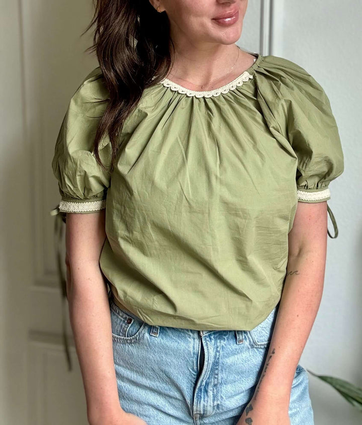 Elegant olive blouse with lace trim, featuring puff sleeves and feminine silhouette, perfect for Christian women's fashion.