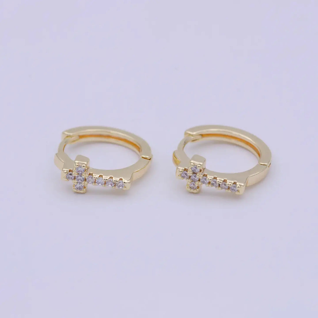 Eternal Grace Huggie Earrings featuring a delicate cross design in 14K gold plating and sparkling accents.