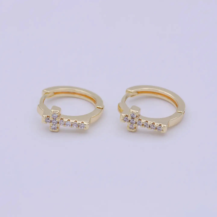 Eternal Grace Huggie Earrings featuring a delicate cross design in 14K gold plating and sparkling accents.