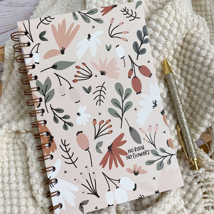 Spiral-bound No Rain No Flowers notebook with floral design, perfect for Christian women journaling and devotionals.