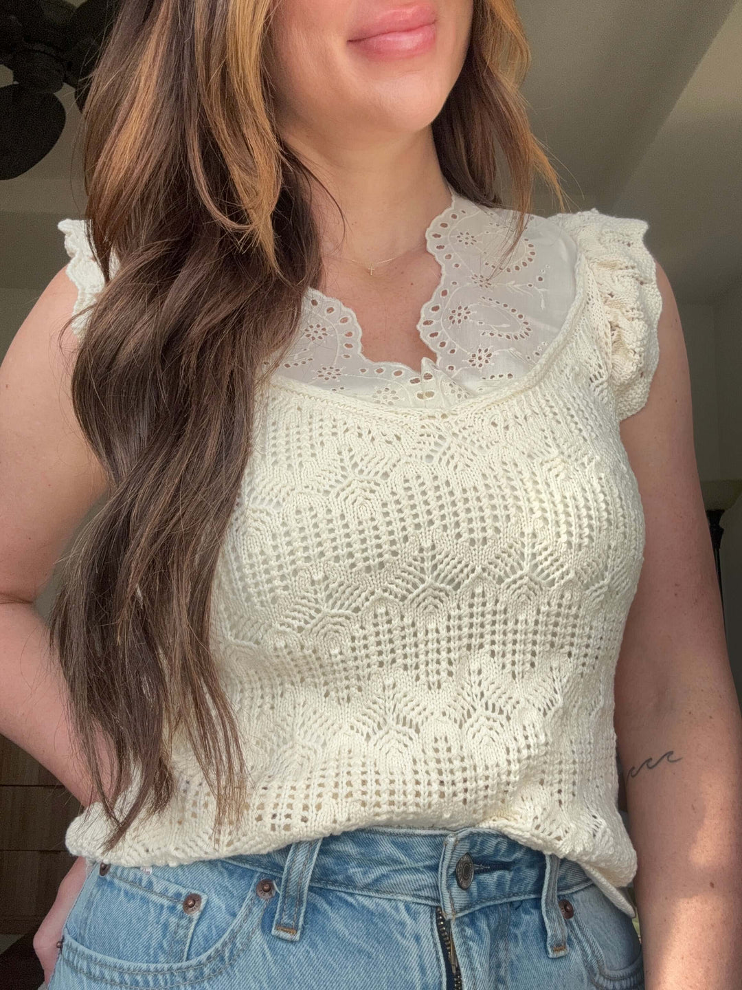 Close-up of a woman wearing a cream crochet top with floral lace collar, perfect for stylish summer outfits.