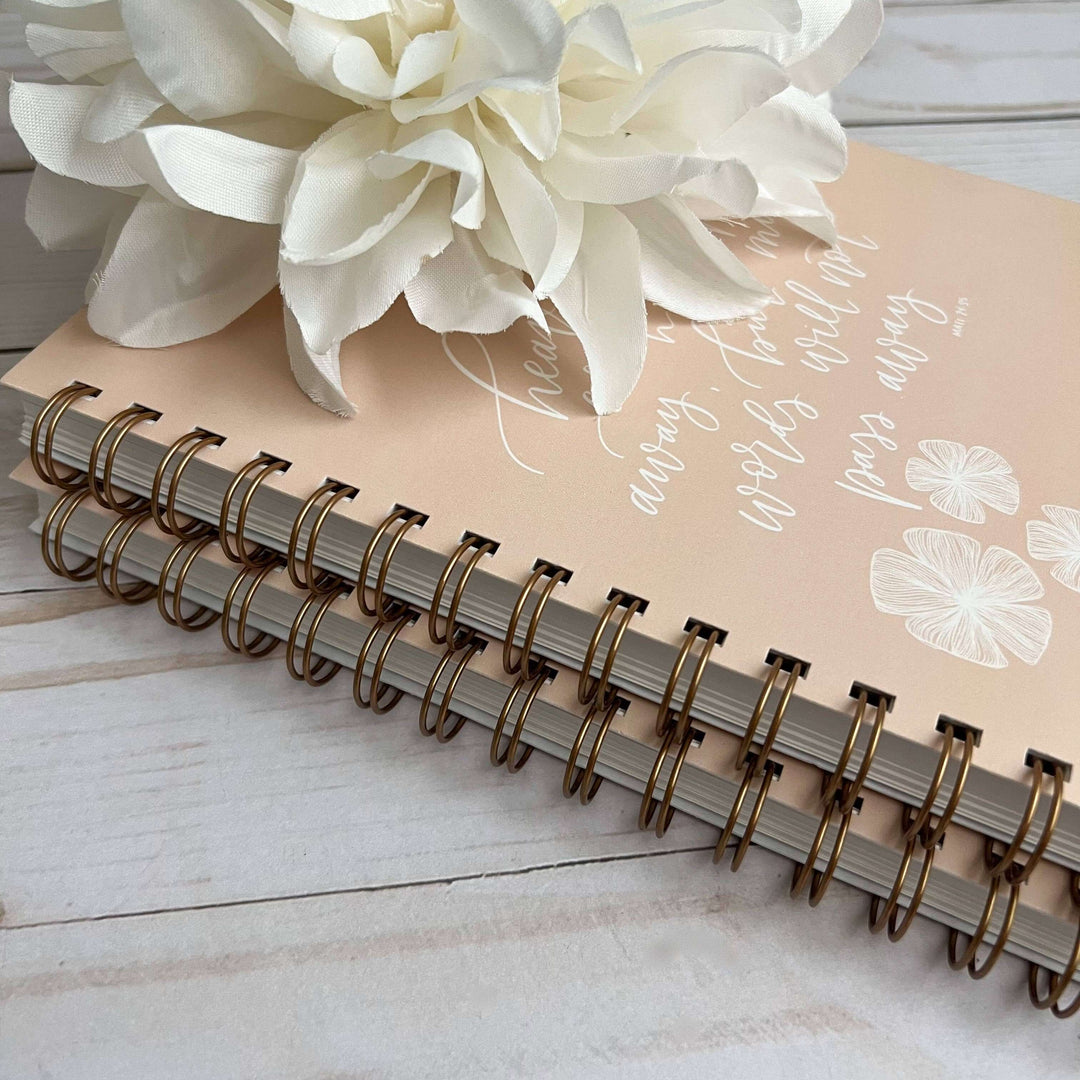Faith-Fueled Planner for Christian women, featuring elegant floral design and spiral binding on a wooden surface.