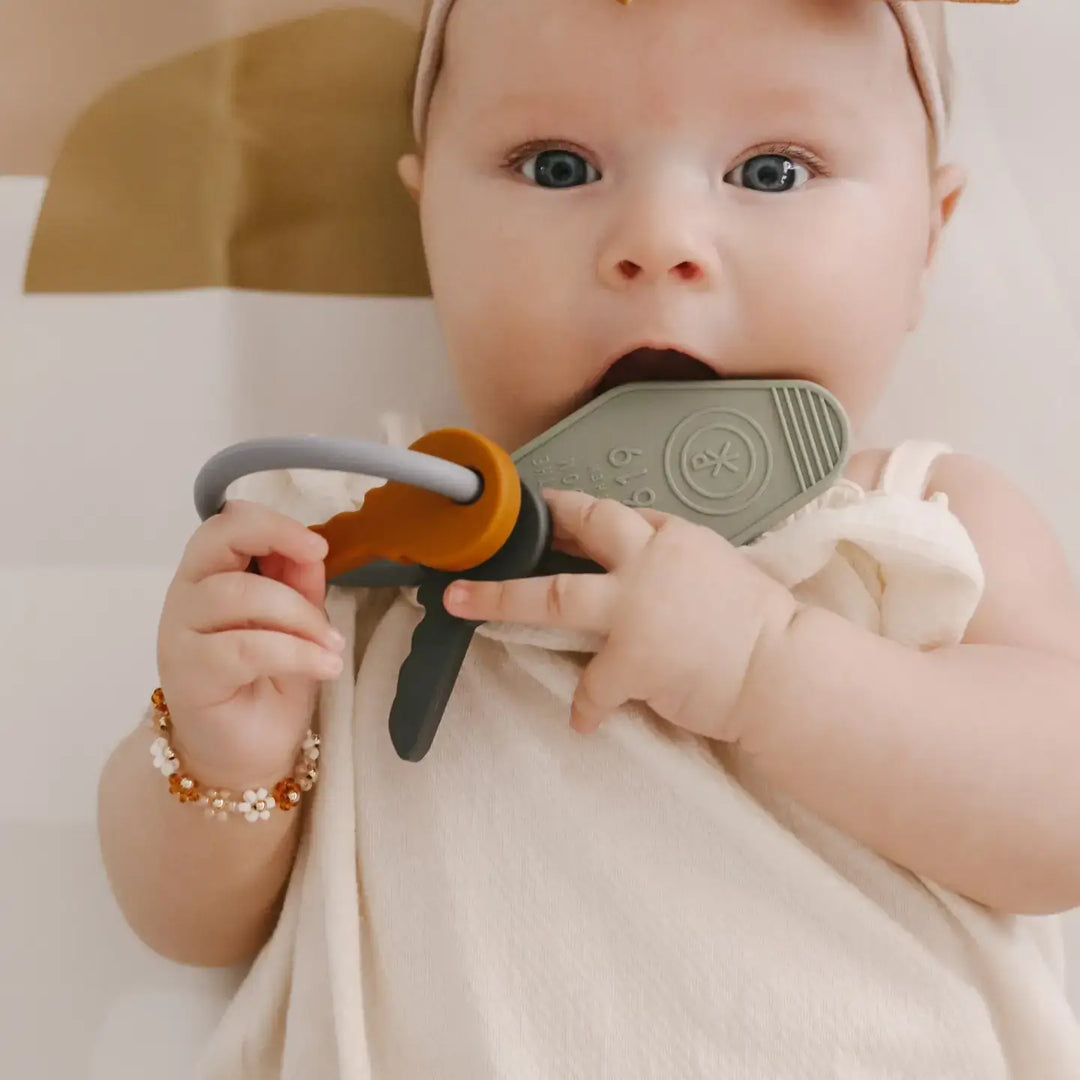 Baby enjoying the Keys to the Kingdom silicone teether, symbolizing faith and love, with colorful key designs.