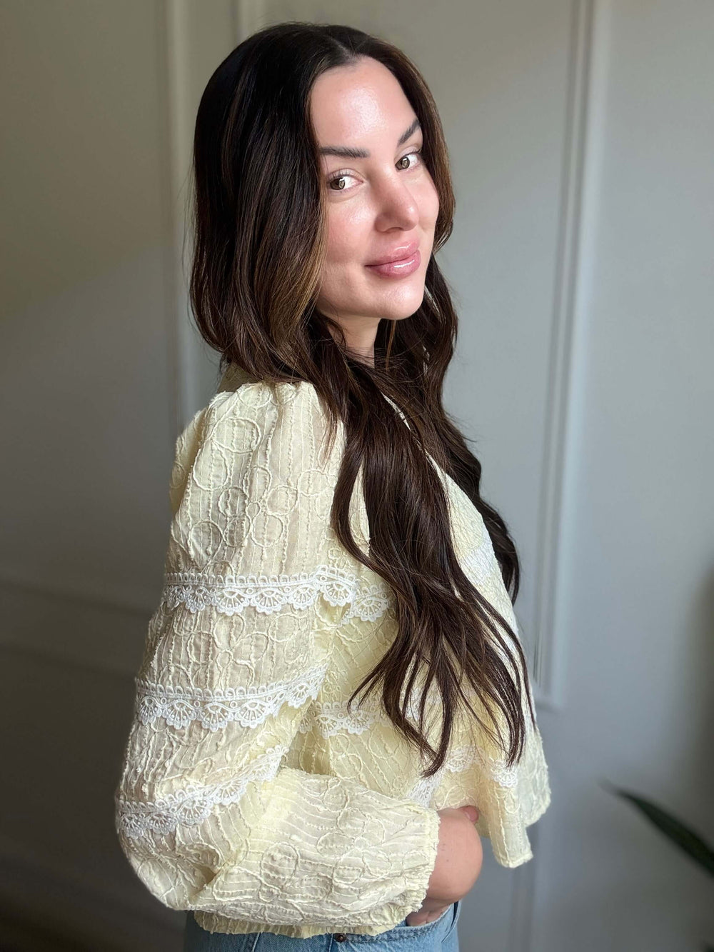 Model showcasing Luminous Blouse in soft yellow with intricate lace details, embodying elegance and comfort.