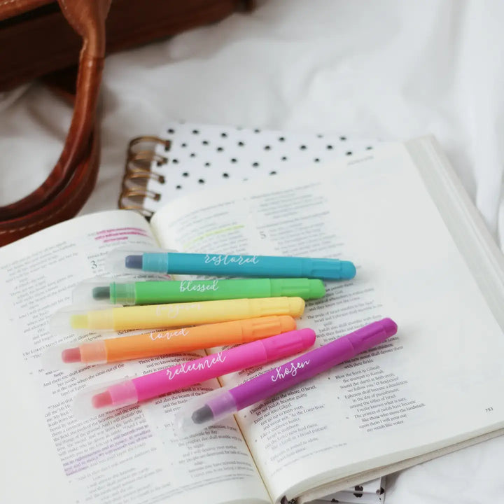 Colorful scented Bible highlighter set on an open page, showing six gel highlighters with inspirational words.
