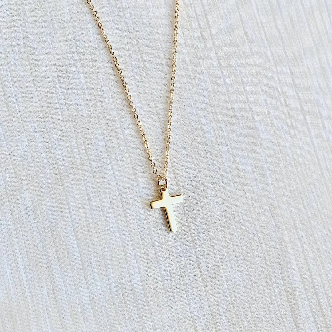 Dainty gold cross necklace on a delicate chain, perfect for expressing faith in style.